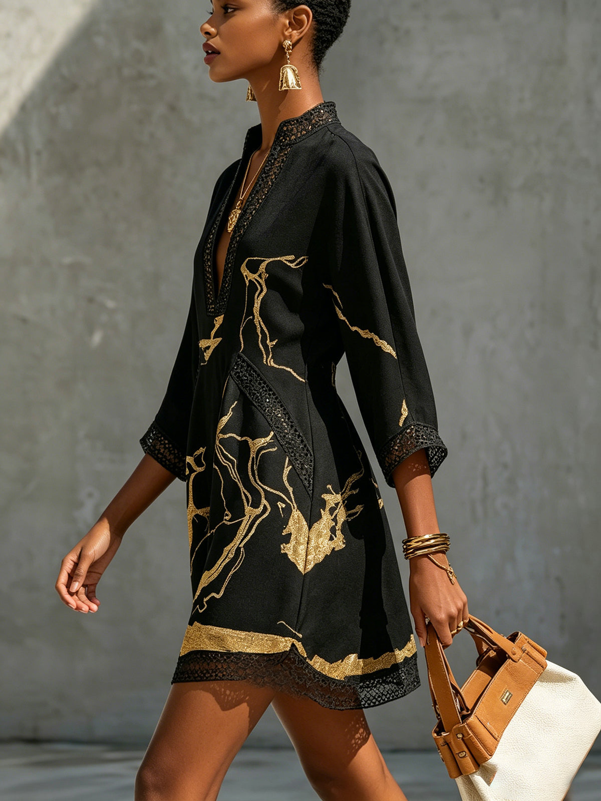 Ébène | Mini-jurk met V-hals en zwart-gouden print